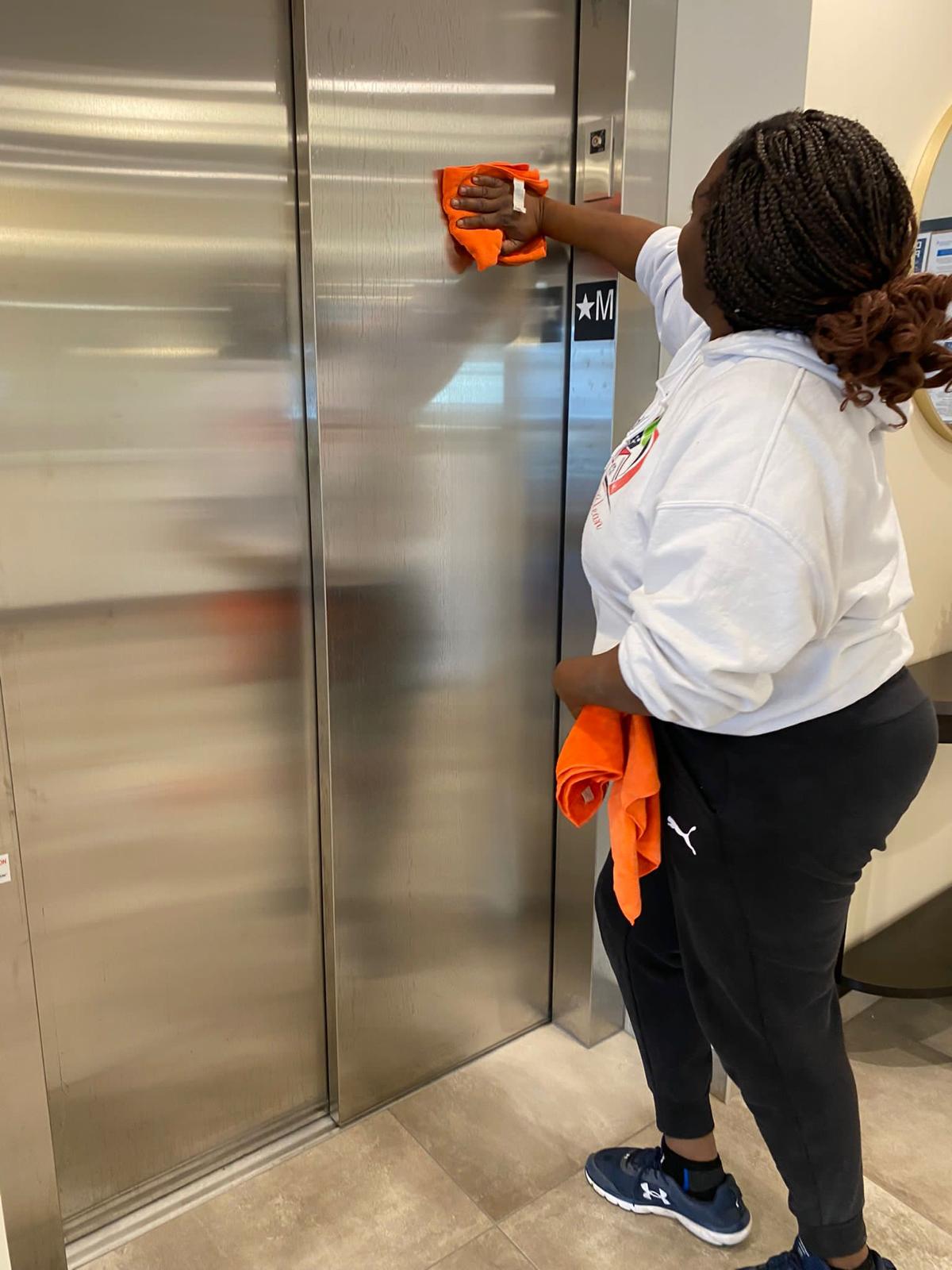 Kanians team member cleaning elevator doors in commercial building