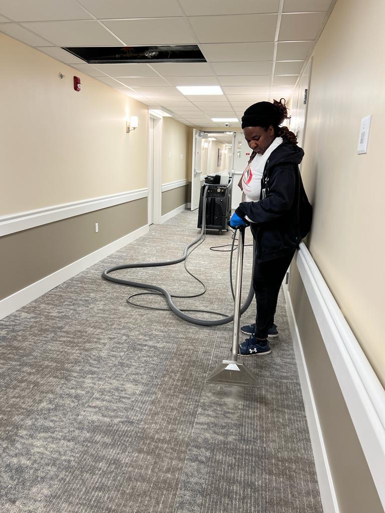 Kanians team member performing carpet extraction in commercial hallway