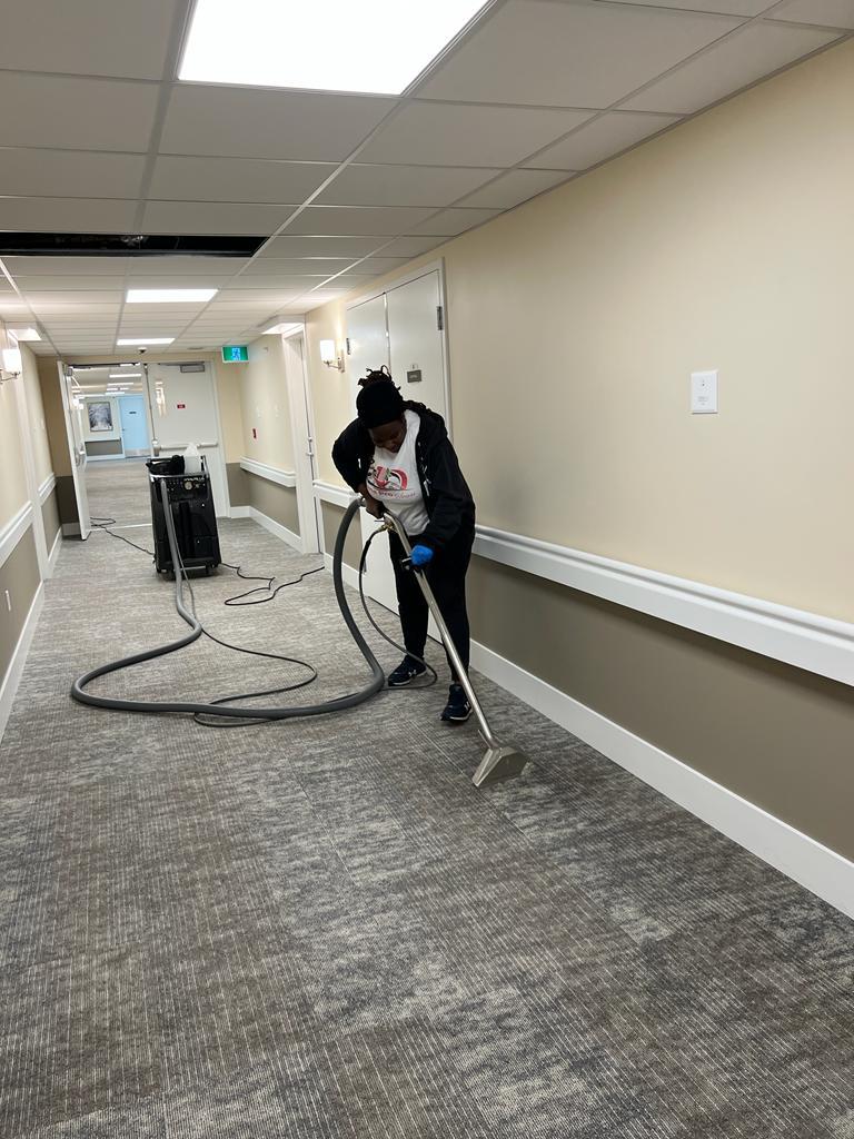 Kanians team member doing commercial carpet extraction in hallway