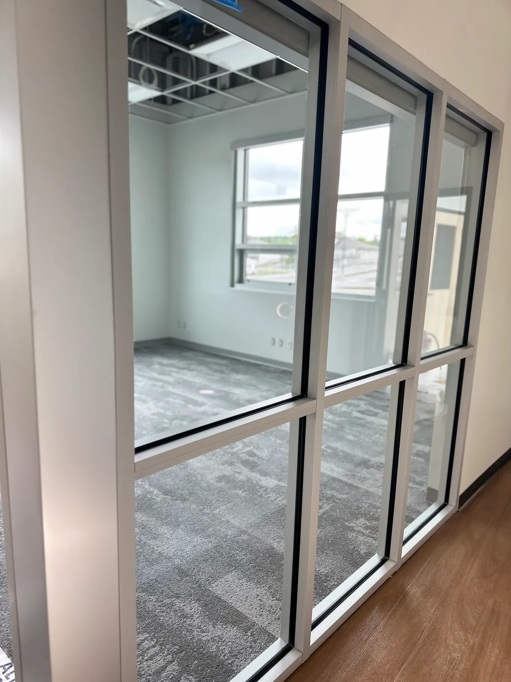 Newly constructed commercial office with glass partitions, cleaned and ready for occupancy after post-construction work